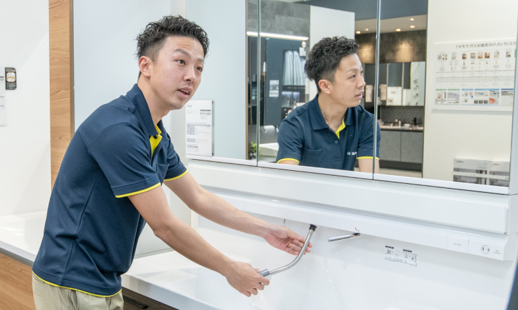 洗面台の機能を説明しているスタッフ